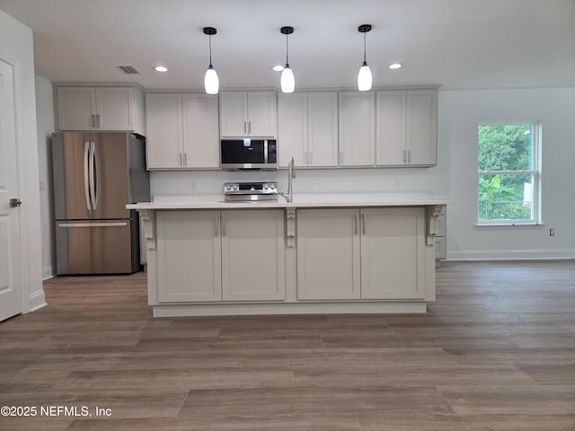 54356 Jamie Dr, Callahan, FL 32011 - kitchen featuring stainless steel appliances, light countertops, recessed lighting, hanging light fixtures, and a center island with sink