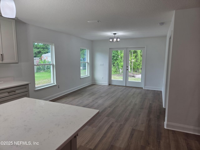 54356 Jamie Dr, Callahan, FL 32011 - unfurnished dining area with dark wood-style floors, a chandelier, baseboards, and a textured ceiling