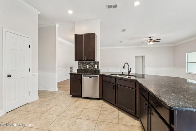 kitchen with a sink, visible vents, dark brown cabinets, wainscoting, and dishwasher