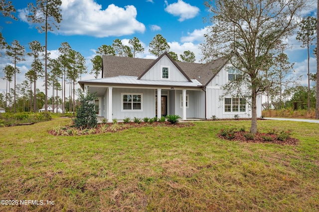 modern farmhouse style home featuring board and batten siding, a front yard, a standing seam roof, and metal roof