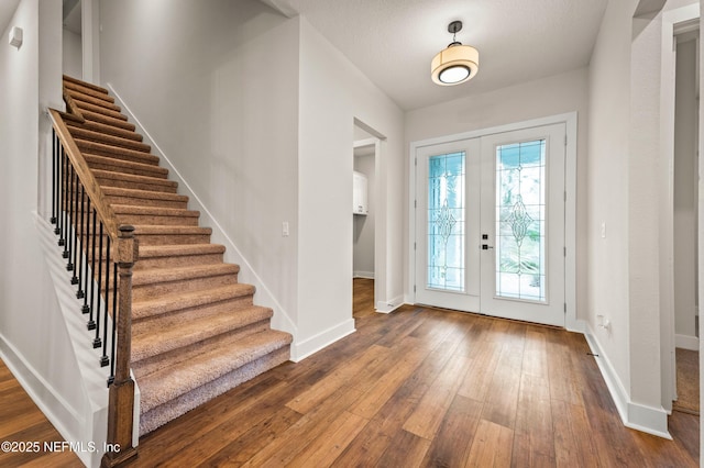 entrance foyer featuring stairway, french doors, wood-type flooring, and baseboards