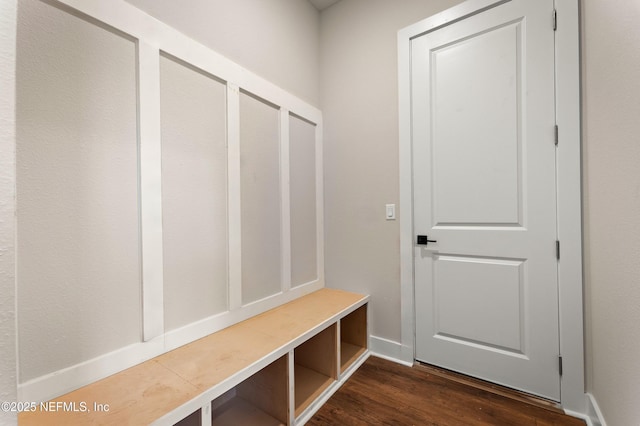 mudroom with dark wood-style flooring and baseboards