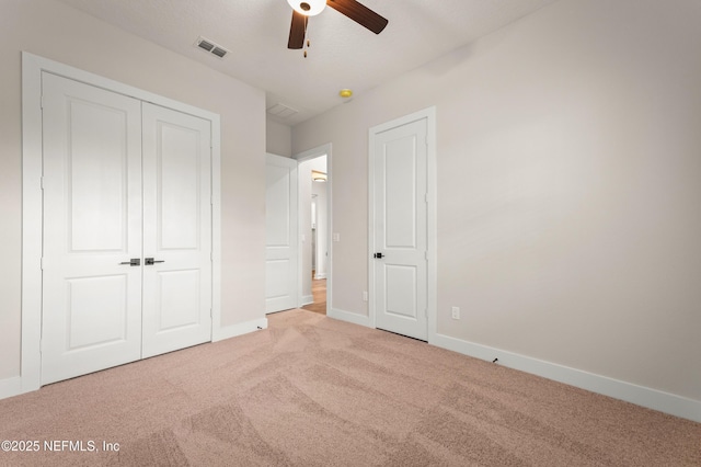 unfurnished bedroom with baseboards, visible vents, ceiling fan, and carpet flooring