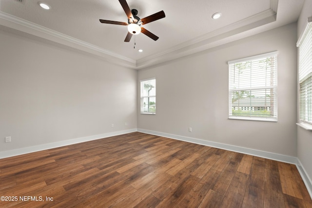 unfurnished room with plenty of natural light, a tray ceiling, and crown molding