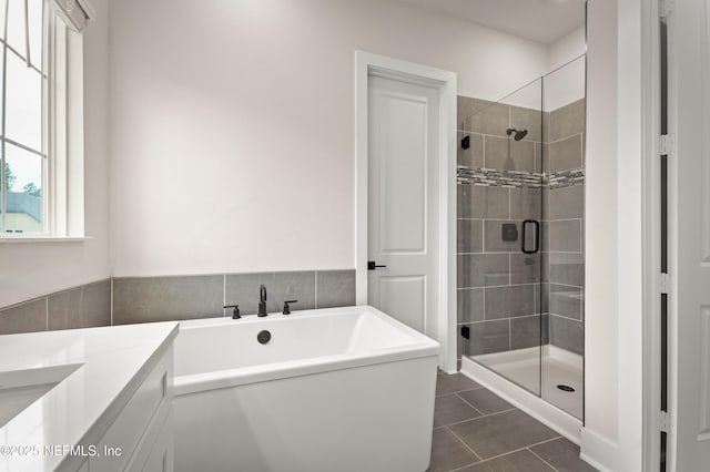 full bathroom featuring a soaking tub, a shower stall, vanity, and tile patterned floors