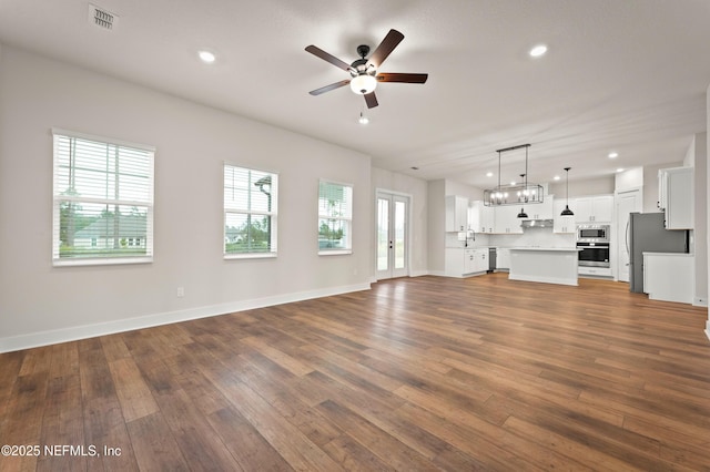 unfurnished living room with baseboards, visible vents, ceiling fan, dark wood-type flooring, and recessed lighting