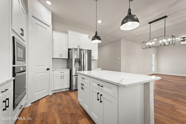 kitchen with stainless steel appliances, pendant lighting, dark wood finished floors, and backsplash