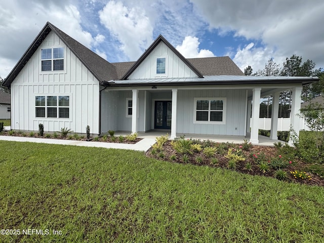 36263 Pitch Ln, Hilliard, FL 32046 - modern farmhouse featuring board and batten siding, french doors, a front yard, covered porch, and roof with shingles