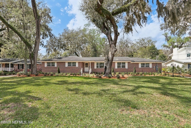 ranch-style house with a front yard and brick siding