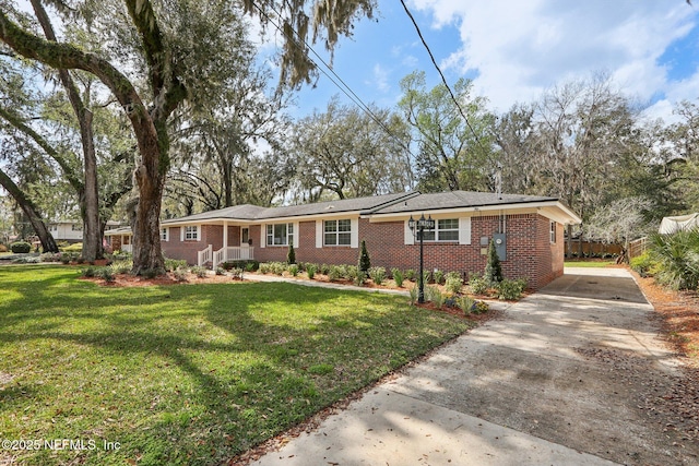 ranch-style house featuring brick siding, concrete driveway, and a front lawn