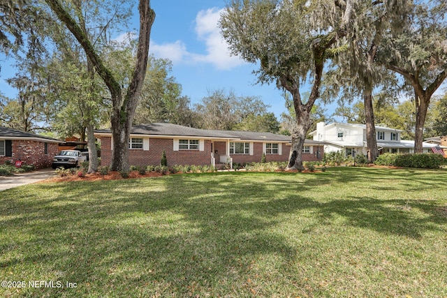 view of front facade with brick siding and a front yard