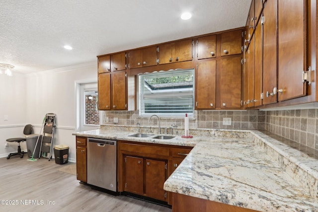 kitchen featuring light wood-style flooring, a sink, backsplash, brown cabinetry, and dishwasher