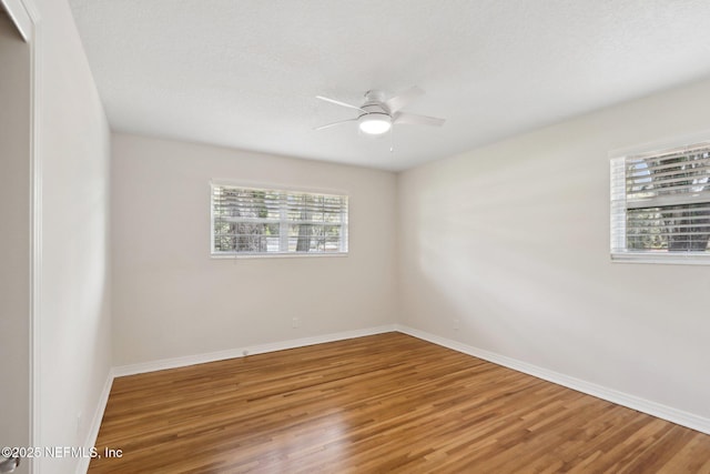 empty room featuring baseboards, wood finished floors, and ceiling fan