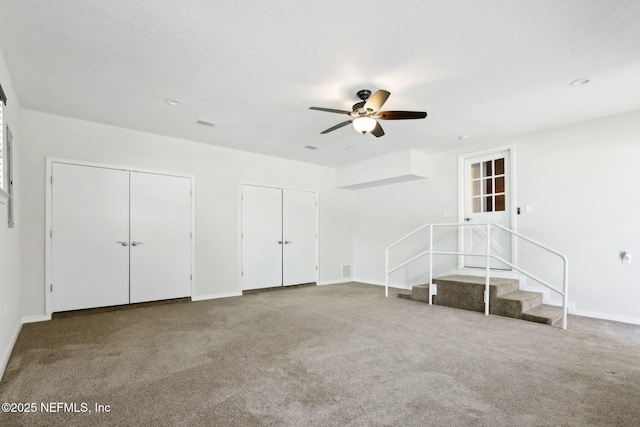 unfurnished living room featuring carpet flooring, baseboards, and ceiling fan
