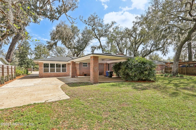 rear view of house featuring a patio area, brick siding, a yard, and fence