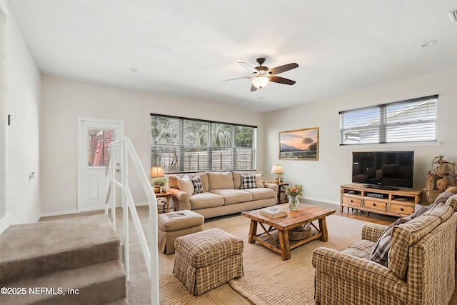 living room with baseboards and ceiling fan