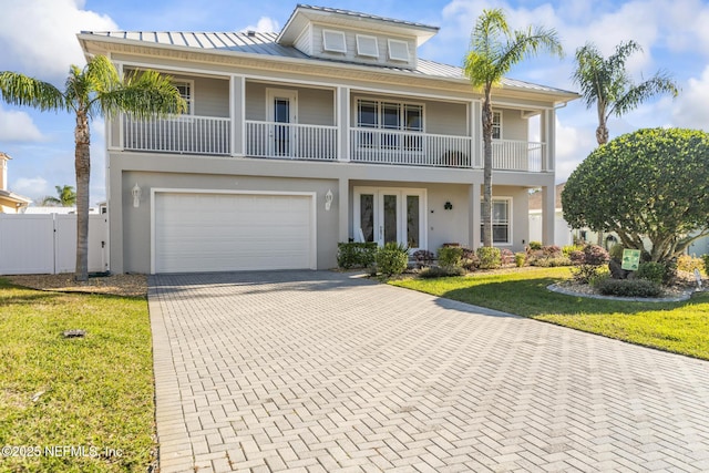 view of front of house featuring a standing seam roof, metal roof, a front lawn, and decorative driveway