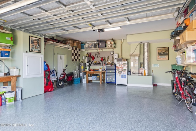 garage featuring a garage door opener, water heater, and baseboards