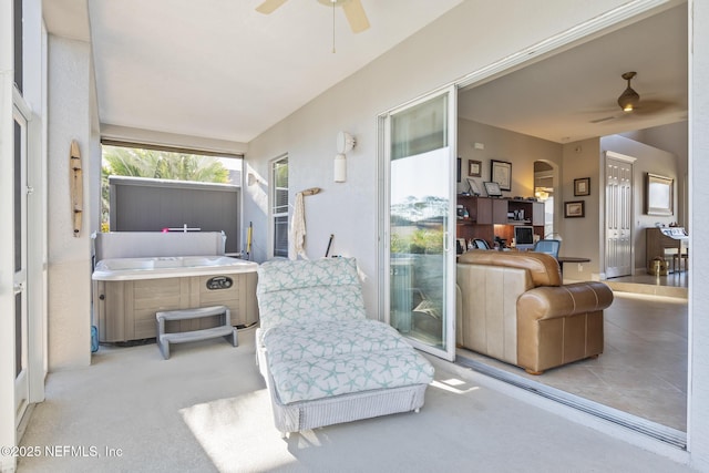 interior space with ceiling fan and a hot tub