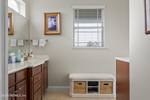full bathroom with a sink, double vanity, tile patterned flooring, and baseboards