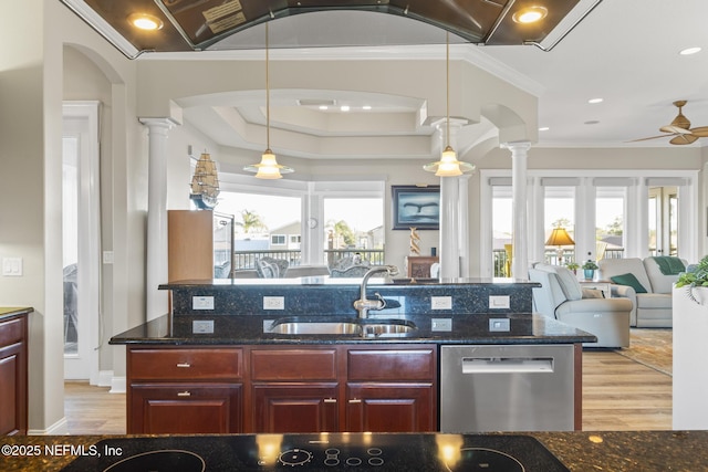 kitchen with a sink, decorative columns, open floor plan, and dishwasher