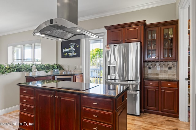 kitchen with crown molding, stainless steel fridge, dark brown cabinets, and island range hood