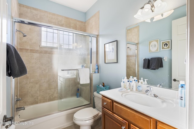 bathroom featuring toilet, enclosed tub / shower combo, and vanity