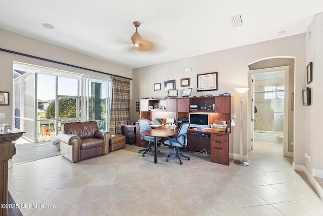office featuring light tile patterned floors, a ceiling fan, visible vents, and baseboards