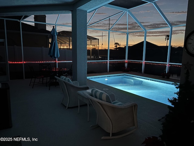 view of pool featuring a patio area, glass enclosure, and a hot tub