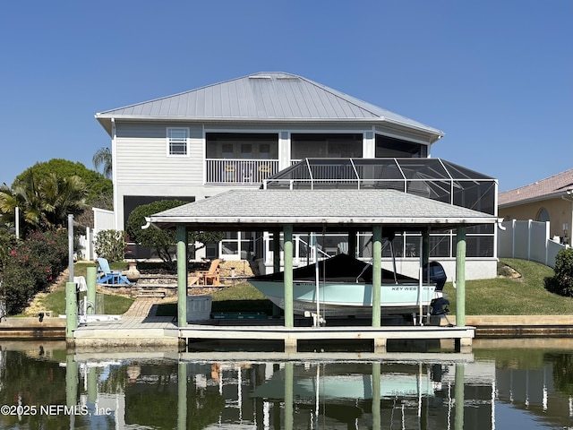 dock area featuring a water view, glass enclosure, and boat lift