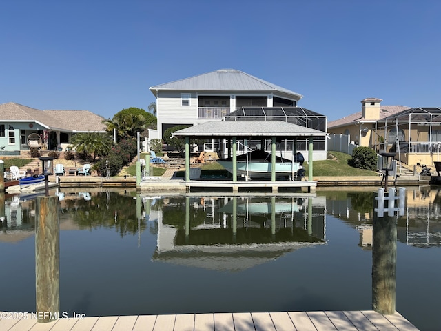 dock area with glass enclosure, a water view, and boat lift