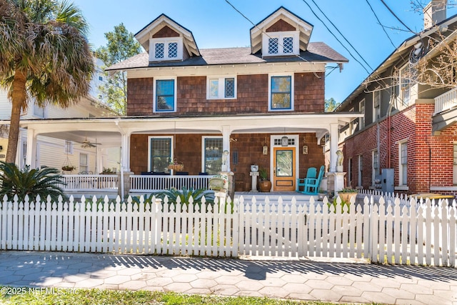 traditional style home featuring a fenced front yard, a gate, and a porch