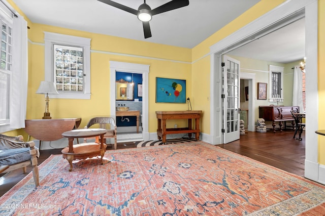 sitting room with baseboards, a ceiling fan, and wood finished floors