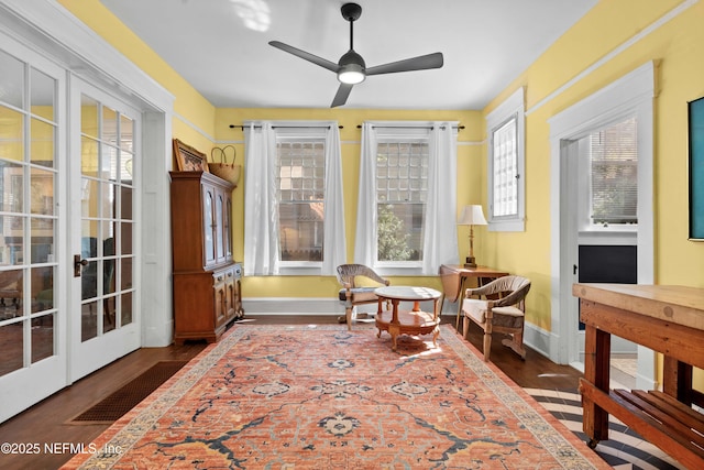 living area featuring dark wood-type flooring, french doors, ceiling fan, and baseboards