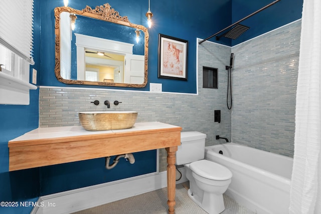 bathroom featuring tile walls, toilet, shower / bath combo with shower curtain, vanity, and tile patterned flooring