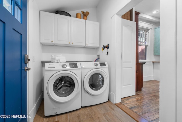 washroom featuring washer and clothes dryer, wood finished floors, and cabinet space