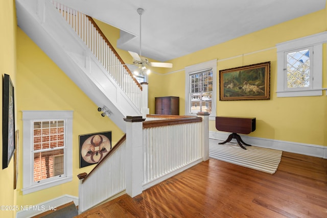 interior space with ceiling fan, baseboards, and wood finished floors