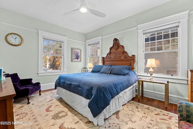 bedroom with a ceiling fan, baseboards, and wood finished floors