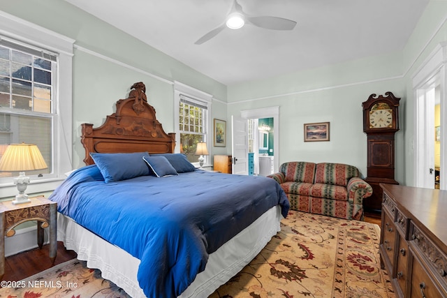 bedroom featuring ceiling fan, ensuite bathroom, and wood finished floors