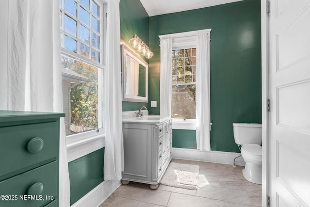 bathroom featuring vanity, toilet, and baseboards