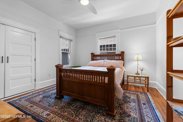 bedroom with ceiling fan, baseboards, and wood finished floors