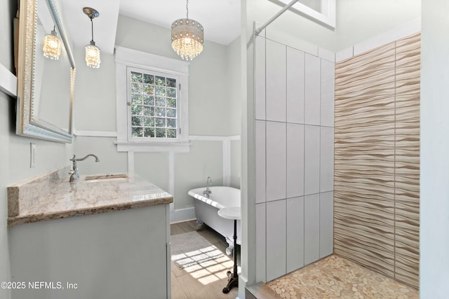 bathroom with a freestanding tub, vanity, and a notable chandelier