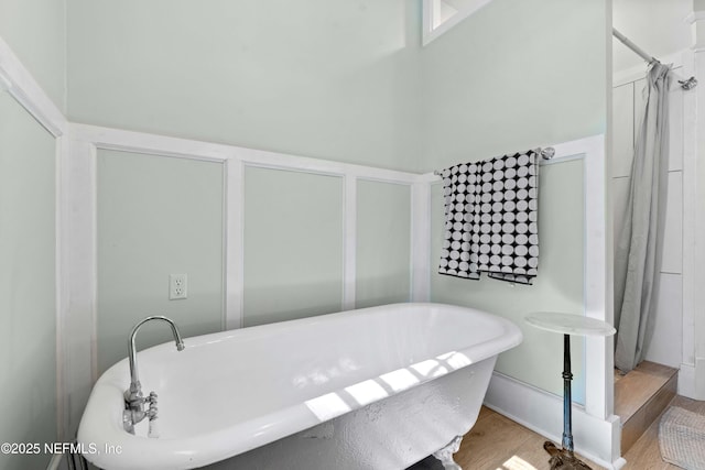 bathroom with a freestanding bath and wood finished floors