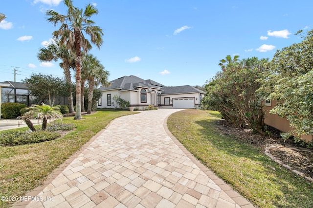 view of front of house with a garage, stucco siding, decorative driveway, and a front yard