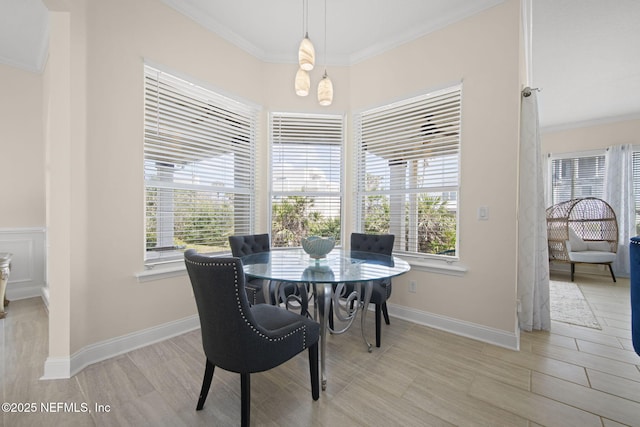 dining room with ornamental molding, plenty of natural light, and baseboards