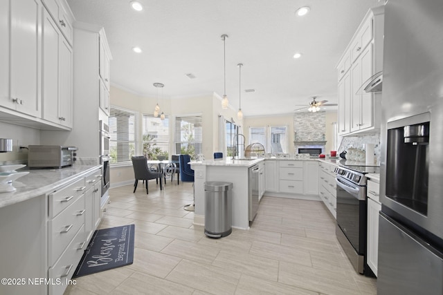 kitchen featuring pendant lighting, crown molding, backsplash, appliances with stainless steel finishes, and a peninsula