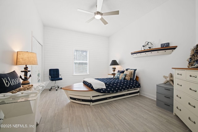 bedroom featuring light wood-style floors, baseboards, and a ceiling fan