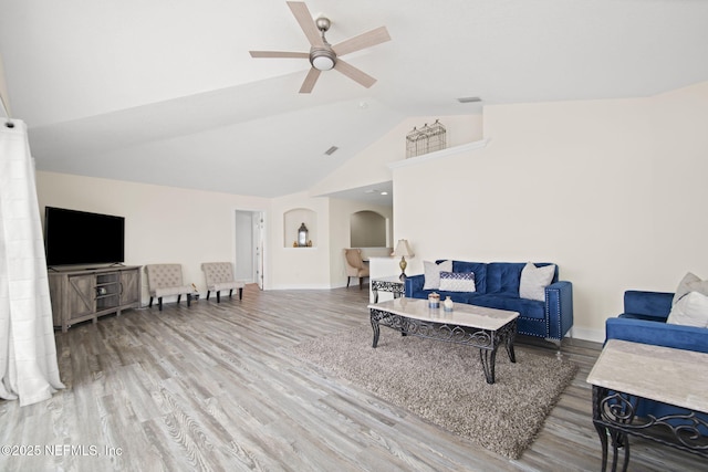 living room featuring arched walkways, high vaulted ceiling, wood finished floors, a ceiling fan, and baseboards