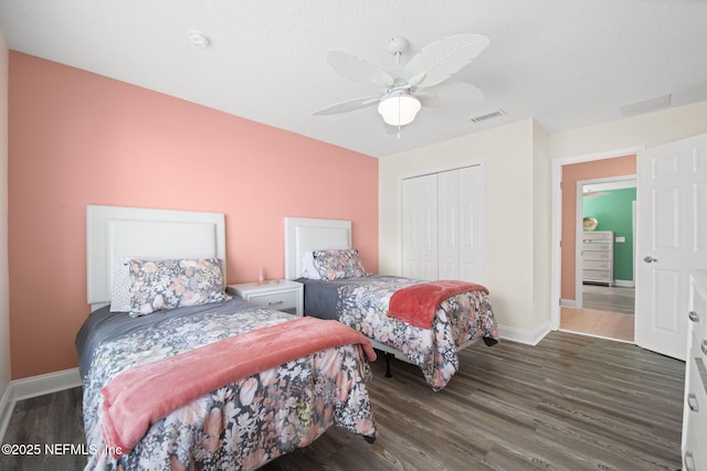 bedroom featuring baseboards, a closet, visible vents, and wood finished floors