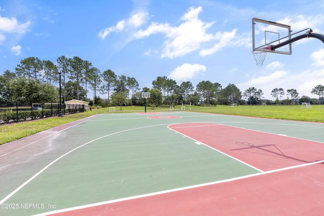 view of basketball court with a yard, community basketball court, and fence